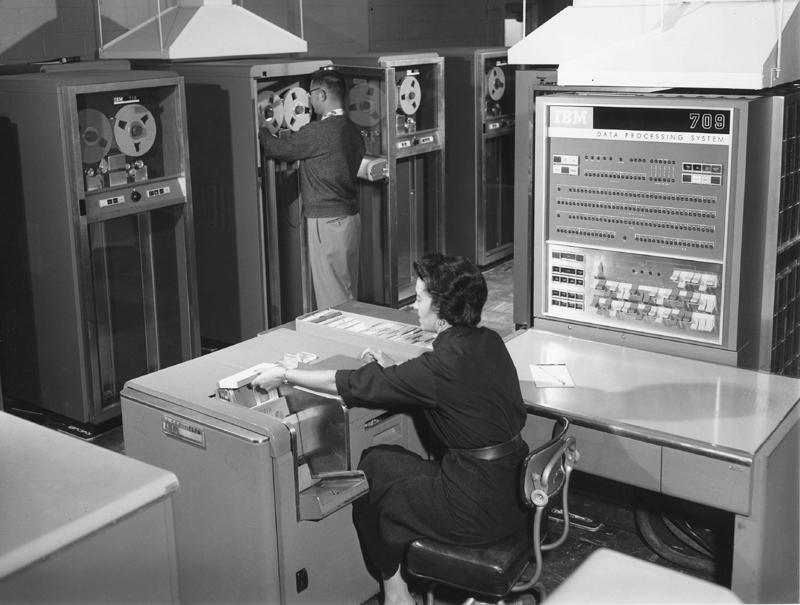 Fig. 2 – Une technicienne charge un programme à l’aide du lecteur de cartes perforées sur un IBM 709 (fin des années 1950)